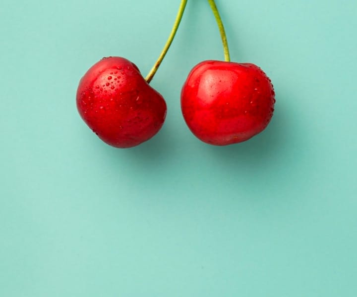 A cherry with a green background